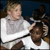 Madonna sits with the two children she adopted in Malawi, David Banda and Mercy James in a classroom of the Mkoko Primary School in Malawi 