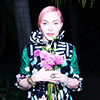 Madonna with pink hair, posing with pink flowers in a green dress.